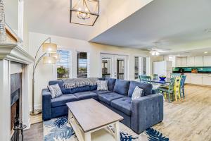 ein Wohnzimmer mit einem blauen Sofa und einem Tisch in der Unterkunft Lost Colony Shiny Shell Cottage in Port Aransas + 31 Fotos