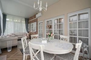 a living room with a white table and chairs at Tündér-Lak Apartman in Balatonmáriafürdő