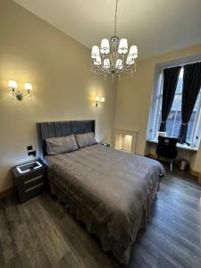 a bedroom with a large bed and a chandelier at Thistle City Inn in Edinburgh