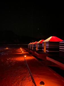 a row of umbrellas on a pier at night at Wadi Rum Orion Camp in Wadi Rum
