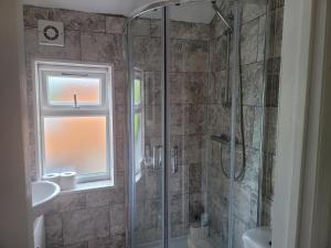 a bathroom with a shower and a sink and a window at Comfy one bedroom flat in Tilehurst