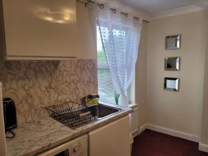 a kitchen with a sink and a window at Comfy one bedroom flat in Tilehurst