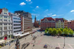 ulica miejska z budynkami i wieżą zegarową w obiekcie Prywatne studio dla 4 osób z widokiem na Rynek i Plac Solny! we Wrocławiu