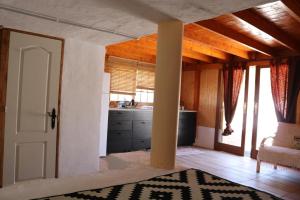 una cucina con porta bianca e una camera con tavolo di Half wooden rural apartment a Fasnia