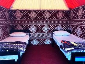 two beds in a room with a red ceiling at Wadi Rum Orion Camp in Wadi Rum