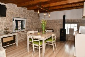 een keuken en eetkamer met een tafel en stoelen bij Great place for relaxation in Gornji Proložac