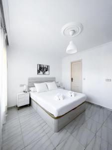 ein weißes Schlafzimmer mit einem Bett und einer weißen Wand in der Unterkunft Residencial Portonovo in Portonovo