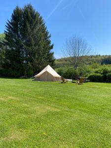 a tan tent in a field of green grass at My Friends Place in Oneonta