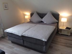 a bedroom with a large bed with two lamps at Pension Roseneck in Wolfshagen