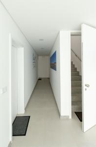 an empty hallway with white walls and stairs at Sun House - Alojamento Local - Ponte de Lima in Ponte de Lima
