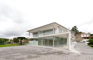 un gran edificio blanco con ventanas de cristal en una calle en Sun House - Alojamento Local - Ponte de Lima en Ponte de Lima