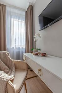 a living room with a tv and a chair at SMARAGD-Emerald in Veszprém