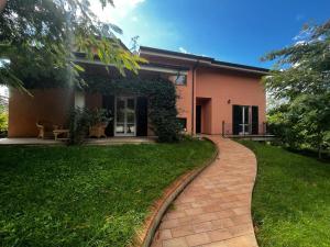 uma casa com um passadiço de tijolos em frente em casa mimose rosa II em SantʼAngelo in Pontano