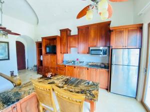 a kitchen with wooden cabinets and a granite counter top at Beach Front Condo steps from beach in Six Huts