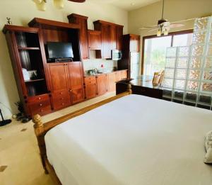a bedroom with a white bed and a kitchen at Beach Front Condo steps from beach in Six Huts