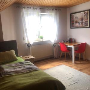 a bedroom with a bed and a table and a window at Gemütliches zwei Zimmer Apartment in Bamberg