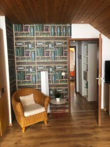 Zimmer mit einem Stuhl und einer Bücherwand in der Unterkunft Gemütliches zwei Zimmer Apartment in Bamberg