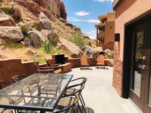 un patio con sillas y una mesa de cristal en Bluff Dwellings Resort en Bluff