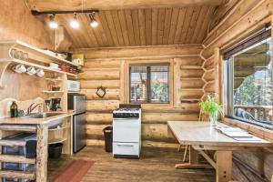 cocina con paredes de madera, mesa y fogones en Pink Salmon en Soldotna