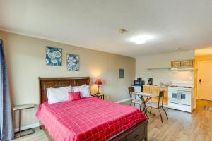 1 Schlafzimmer mit einem roten Bett und einer Küche in der Unterkunft New River Gorge Vacation Rental with Balcony! in Fayetteville