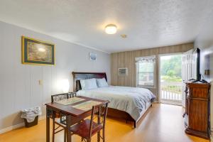 Schlafzimmer mit einem Bett, einem Tisch und einem Fenster in der Unterkunft Nifty Fayetteville Vacation Rental Near New River! in Fayetteville