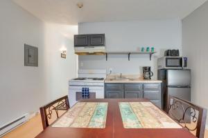 a kitchen with a table and a stove and refrigerator at Nifty Fayetteville Vacation Rental Near New River! in Fayetteville