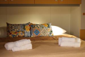 a bed with two rolled towels on it at Il giardino di Mondello in Mondello