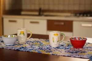 three coffee mugs on a table in a kitchen at Il giardino di Mondello in Mondello