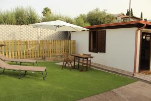 a patio with a table and an umbrella at Il giardino di Mondello in Mondello