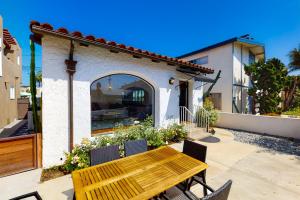 a wooden table and chairs in front of a house at Belmont Shore Stunner in Long Beach
