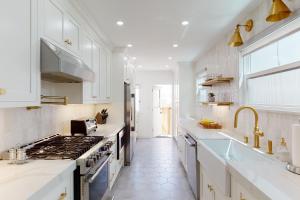 a white kitchen with a stove and a sink at Belmont Shore Stunner in Long Beach