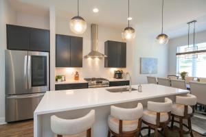 a kitchen with a large white island with bar stools at Luxury Townhome Skyline Views Mins To DT in Nashville