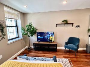 a living room with a couch and a tv and a chair at 408 Modern styles apartment in center city of Philly in Philadelphia