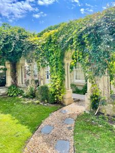 a garden with an arch covered in vines at Cosy One Bedroom Apartment in Trowbridge