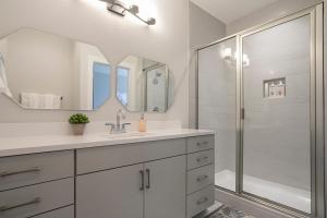 a white bathroom with a sink and a shower at Luxury Townhome Skyline Views Mins To DT in Nashville