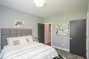 ein Schlafzimmer mit einem großen Bett mit weißer Bettwäsche in der Unterkunft Luxury Townhome Skyline Views Mins To DT in Nashville