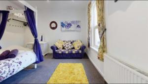 um quarto com uma cama, um sofá e uma janela em Myrtle villa 10 bedrooms sleeps 28, 2 min to beach em Melcombe Regis