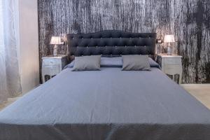- une chambre avec un lit bleu et 2 tables de nuit dans l'établissement Flower Rooms Cagliari, à Cagliari