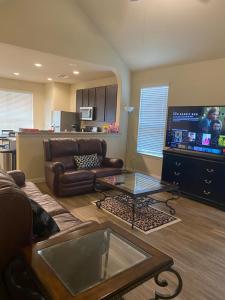 een woonkamer met een bank en een tv bij Kenny Place Park row Katy, Texas in Katy
