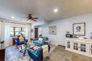 a living room with blue chairs and a ceiling fan at Abruzzi - Villa A in Eatonton 
