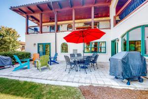 a patio with a table and chairs and a red umbrella at Abruzzi - Villa A in Eatonton 
