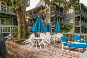 Ein Haufen Stühle und Sonnenschirme auf einer Terrasse in der Unterkunft River Song in Dunnellon