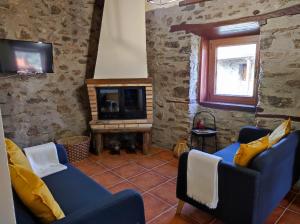 ein Wohnzimmer mit zwei blauen Sofas und einem TV in der Unterkunft Recanto da Encosta - T2 in Bragança