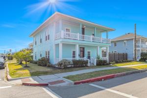 a blue house with a balcony on a street at Beach Stunner in Galveston
