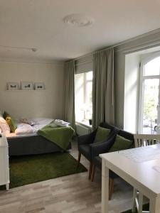 ein Schlafzimmer mit einem Bett, einem Sofa und einem Tisch in der Unterkunft Lilla Drottninggatan Apartment Hotel in Helsingborg
