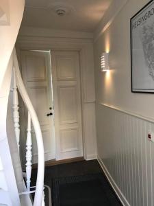 eine Treppe mit einer weißen Tür und einer weißen Treppe in der Unterkunft Lilla Drottninggatan Apartment Hotel in Helsingborg