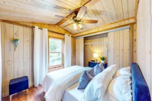 1 dormitorio con paredes de madera y ventilador de techo en Monaville, 