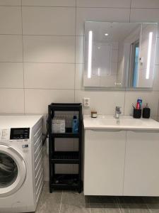 een keuken met een wasmachine en een wastafel bij Leilighet i Trondheim in Trondheim