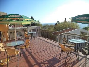 a deck with tables and chairs and umbrellas at Vito Apartments Sutomore in Sutomore