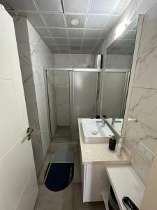 ein Bad mit einer Dusche, einem Waschbecken und einem Spiegel in der Unterkunft Toya in Antalya